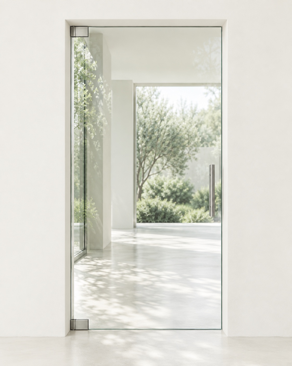 Frameless glass entrance with ivory walls and sage greenery